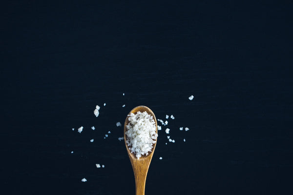 spoon with salt on a dark blue background