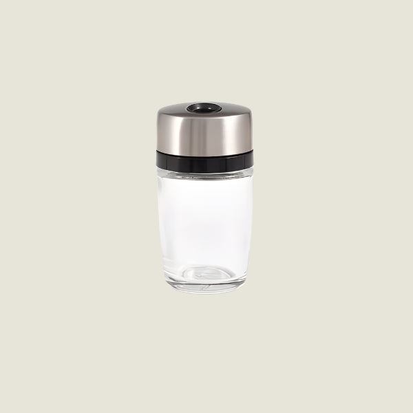 The Cole & Mason Cambridge Herb & Spice Carousel Jar Single, a clear glass spice jar with an airtight lid, is centered against a light beige background, ideal for storing spices or seasonings.