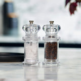 #pepper
The Cole & Mason 505 Salt & Pepper Mills, featuring a sleek clear acrylic design, are displayed side by side—one filled with salt, the other with peppercorns—on a marble countertop with a blurred background.