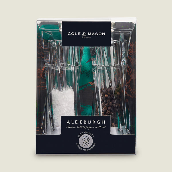 The Cole & Mason Aldeburgh Salt & Pepper Mill Set features clear glass grinders with premium, adjustable mechanisms, filled with coarse salt and whole black peppercorns—perfect for quality seasoning.