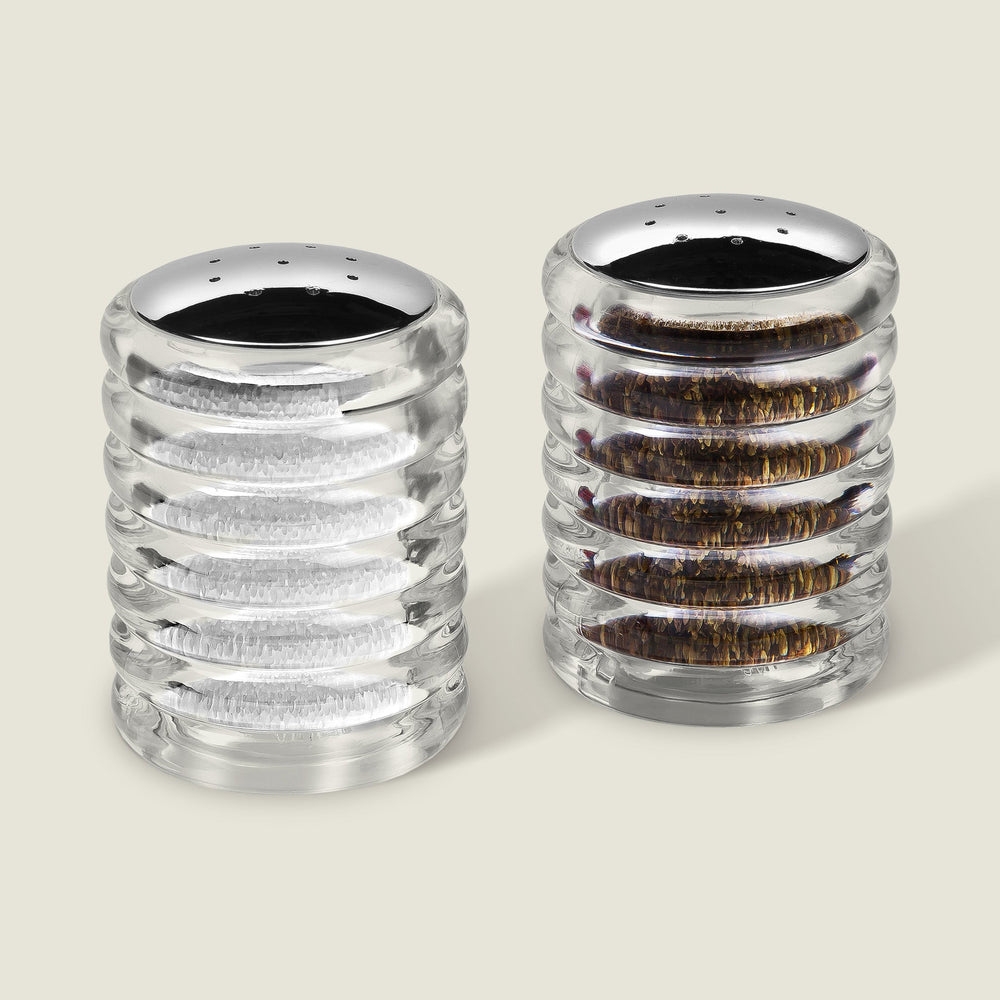 The Cole & Mason Beehive Shakers Set features two ribbed acrylic dispensers with shiny silver tops, filled with white salt and black pepper, displayed side by side on a light background for lasting style.