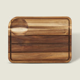 The Cole & Mason Berden Acacia Carving Board features a rectangular design with rounded corners, a recessed juice groove, and a circular indentation. Its striped acacia wood pattern adds style to your kitchen.