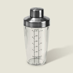 The Cole & Mason Cambourne Salad Dressing Shaker features clear glass with a stainless steel lid and measurement lines in ounces, milliliters, and cups—ideal for mixing cocktails, vinaigrettes, or dressings on any surface.
