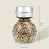 The Darlington Shakers Set by Cole & Mason features a glass and stainless steel spice grinder for seasoning control, filled with pepper granules, measuring 83 mm tall by 62 mm wide; Cole & Mason is labeled on the top. Dimensions shown right and bottom.