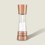 The Cole & Mason Derwent Copper Salt & Pepper Mills feature a sleek, modern design with a transparent body to display white salt crystals and stylish copper accents, blending contemporary aesthetics with precise grinding technology.