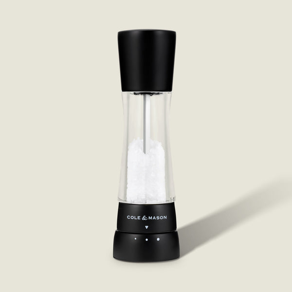 #salt The Cole & Mason Derwent Matt Black Salt & Pepper Mill stands upright on a light background, featuring an acrylic body with a transparent middle, adjustable grind settings, and sleek black top and base.