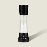 #salt The Cole & Mason Derwent Matt Black Salt & Pepper Mill stands upright on a light background, featuring an acrylic body with a transparent middle, adjustable grind settings, and sleek black top and base.