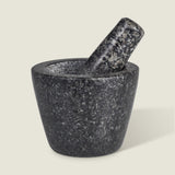 The Cole & Mason Dorchester Granite Pestle & Mortar, in dark gray with speckled detail, sits on a light background. The pestle rests inside the bowl, angled right—ideal for grinding herbs or making fresh spice blends.