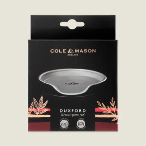 The Cole & Mason Duxford Ceramic Spoon Rest comes in a sleek black box, featuring a grey rest with gold and pink accents—an elegant touch for your kitchen.