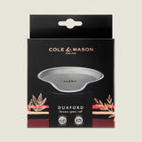 The Cole & Mason Duxford Ceramic Spoon Rest comes in a sleek black box, featuring a grey rest with gold and pink accents—an elegant touch for your kitchen.