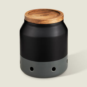 The Cole & Mason Elmdon Ceramic Garlic Keeper, in black and gray with a wooden lid and round ventilation holes, offers stylish garlic storage and appears against a light background.