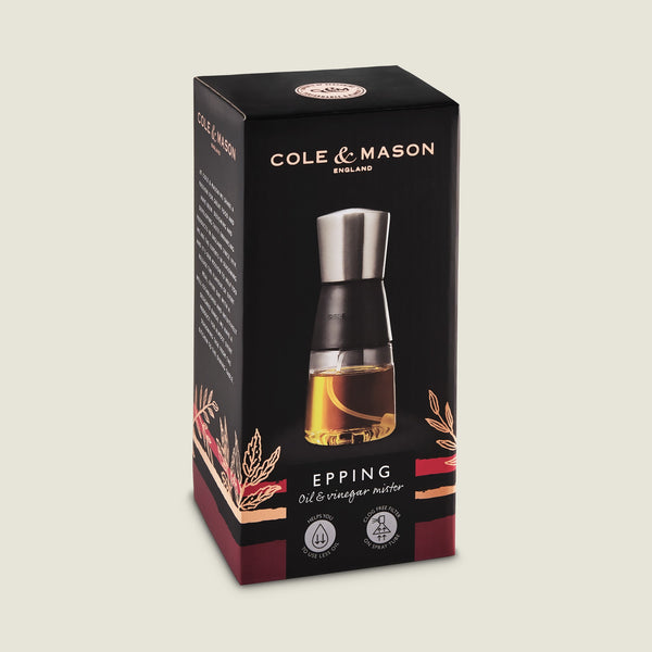 The boxed Cole & Mason Epping Oil & Vinegar Mister features a black and silver design, visible in the clear front image. Its packaging highlights the fine misting mechanism for healthier cooking and includes stylish decorative accents.