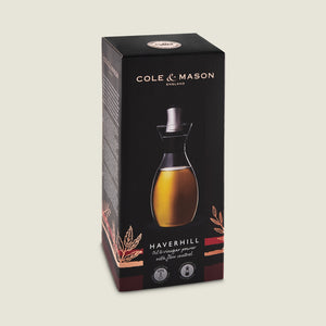A black box displays the Cole & Mason Haverhill Oil & Vinegar Pourer, highlighting its precision spout and featuring an image of the glass pourer filled with golden liquid on the front.