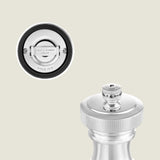 Close-up of a silver Cole & Mason Hoxton Silver Plated Salt & Pepper Mill Set, highlighting the engraved brand name on the top knob and base, with the grinding mechanism visible against a light beige background.