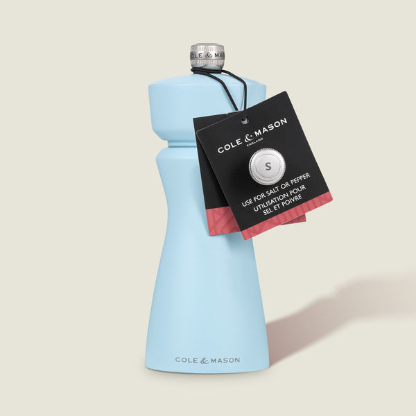 The Cole & Mason Kenton Salt & Pepper Mill in Blue Salt features a refillable design, ceramic mechanism, and a silver top with a black tag. Labeled for salt or pepper, it stands upright on a light background.