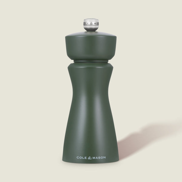 The Cole & Mason Kenton Rosemary Salt & Pepper Mill in matte sage green with a silver top and ceramic mechanism stands upright against a light off-white background.