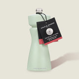 The Cole & Mason Kenton Salt & Pepper Mill in Sage features a ceramic mechanism, a light green body with silver top, and a black tag. Its modern, curved design stands upright and is ideal for both salt or pepper.