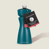 The Cole & Mason Kenton Salt & Pepper Mill in Sea Salt is blue with a silver top, featuring a ceramic mechanism and a minimalist design. A black and red neck tag displays the brand name and product use instructions.
