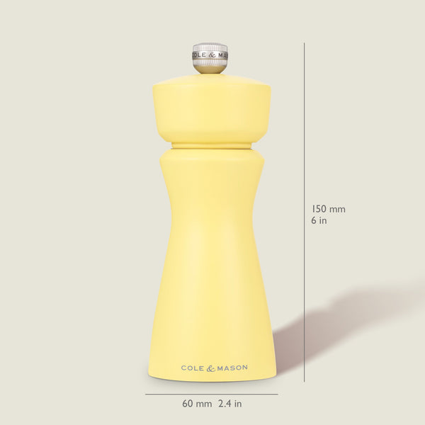 The Cole & Mason Kenton Salt & Pepper Mill in Turmeric Yellow stands upright on a light background, measuring 150 mm tall and 60 mm wide, featuring a silver top knob, ceramic mechanism, and the brand name on its base.