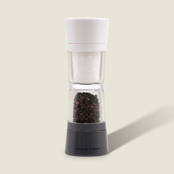 The Cole & Mason Lincoln 2-in-1 Duo Mill grinder has adjustable settings, a white top for salt, and a black base for peppercorns, shown against a light background.