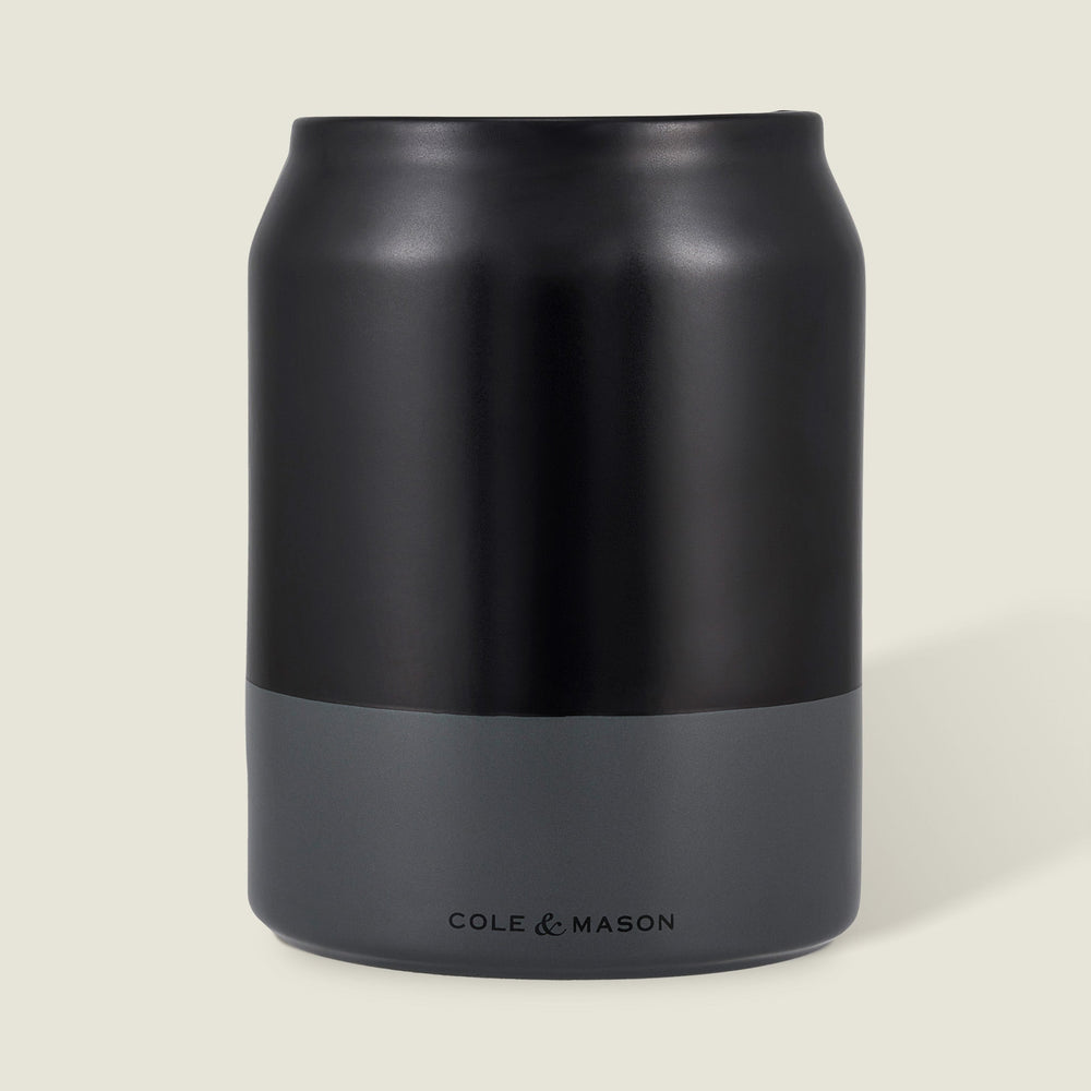 The Cole & Mason Linton Ceramic Utensil Pot, a matte black and gray soda can-shaped container with branding near the base, is ideal for storing cooking utensils and shown against a light beige background.