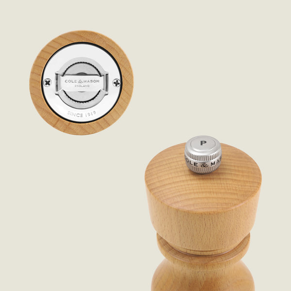 A close-up of the Cole & Mason London Natural Beech Salt Shaker & Pepper Mill Set, featuring a metal-topped grinder labeled P and showcasing Cole & Masons grind select technology. The plain background suits Salt & Pepper Mills enthusiasts.