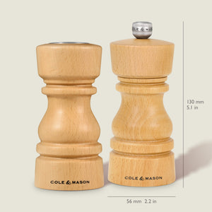 The Cole & Mason London Natural Beech Salt Shaker & Pepper Mill Set, both with grind select technology and branded bases, are shown side by side; the right mill measures 130 mm (5.1 in) tall and 56 mm (2.2 in) wide.