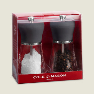 The Cole & Mason Napoli Salt & Pepper Mill Set features quality grinding mechanisms and display windows for salt and pepper levels, all packaged in a red and clear plastic box for easy seasoning customization.