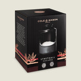 A black and brown Cole & Mason box displays the Strethall Ceramic Salt Pig filled with coarse salt, featuring the brand name, product image, seasoning control details, and decorative leaf accents.