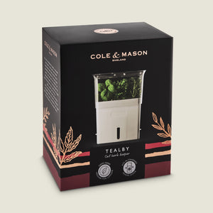 Cole & Mason Tealby Cut Herb Keeper in black and pink packaging, showing the white self-watering herb keeper with fresh herbs inside and decorative herb illustrations on the box.