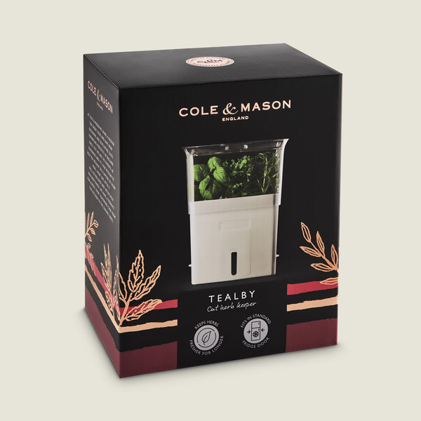 Cole & Mason Tealby Cut Herb Keeper in black and pink packaging, showing the white self-watering herb keeper with fresh herbs inside and decorative herb illustrations on the box.