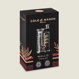 A black and copper Cole & Mason box displays the Wallis Professional Nutmeg Grinder, filled with nutmeg and featuring ergonomic design, with decorative grain illustrations on the packaging.